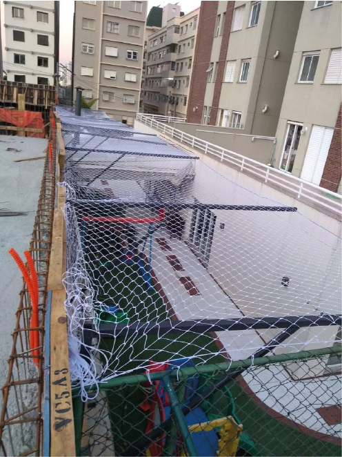Rede de proteção AMM instalada na borda da laje em obra, sistema piso a piso